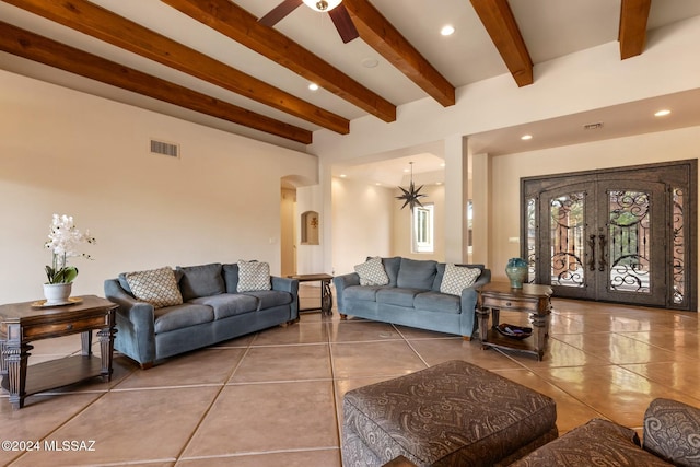 tiled living room featuring beam ceiling, french doors, and ceiling fan