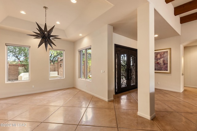 tiled entryway with french doors, vaulted ceiling with beams, a tray ceiling, and ceiling fan