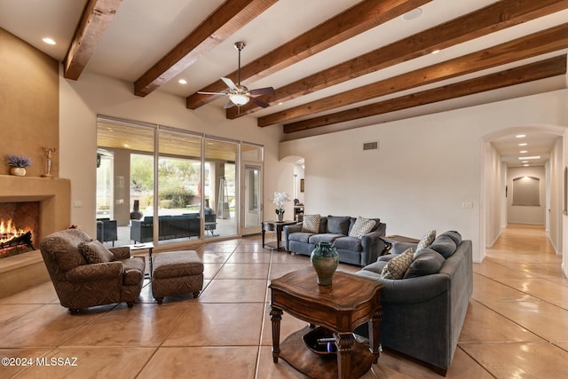 tiled living room with beamed ceiling and ceiling fan