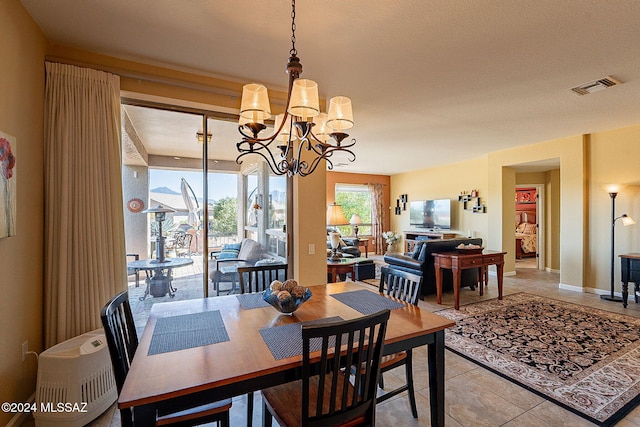 dining space featuring tile patterned flooring and a notable chandelier