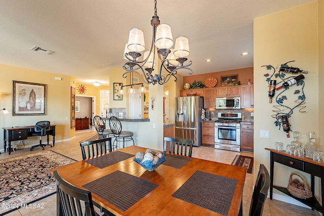 dining space with light tile patterned floors, a textured ceiling, and an inviting chandelier