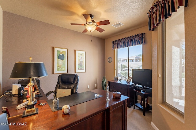 office area featuring ceiling fan, light colored carpet, and a textured ceiling