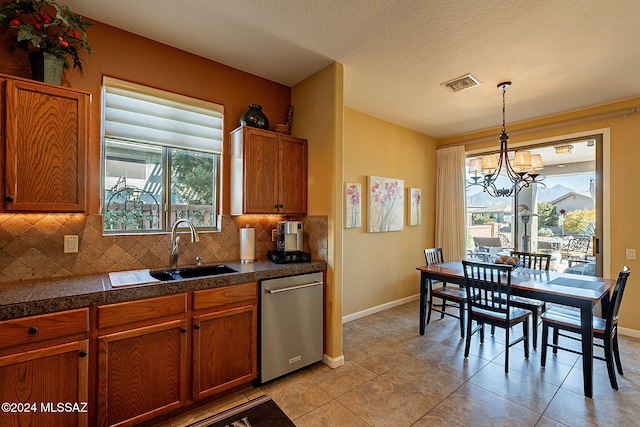 kitchen featuring dishwasher, sink, light tile patterned floors, tasteful backsplash, and a notable chandelier