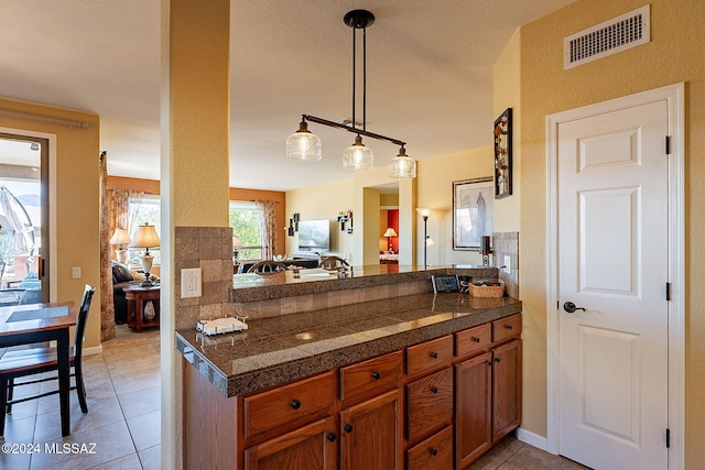 kitchen with decorative light fixtures, light tile patterned flooring, and kitchen peninsula