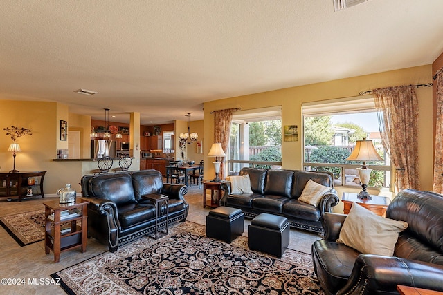 living room with a textured ceiling and a notable chandelier