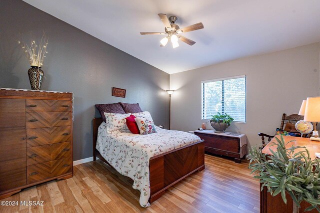 bedroom with ceiling fan, wood-type flooring, and vaulted ceiling