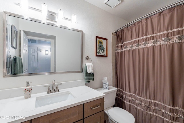 bathroom with vanity, a textured ceiling, and toilet