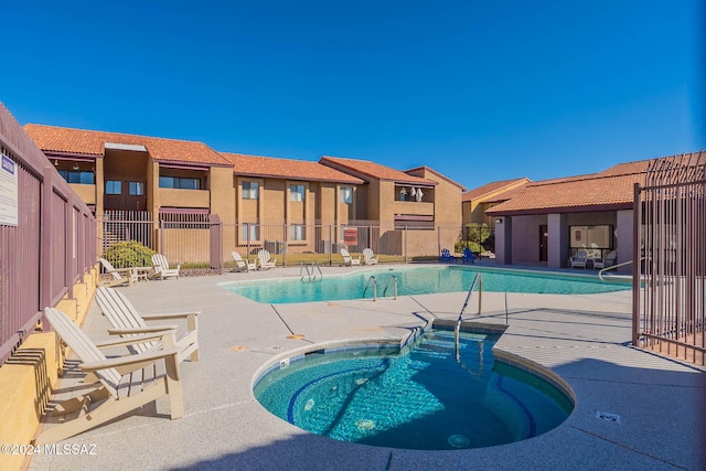 view of pool with a community hot tub and a patio area