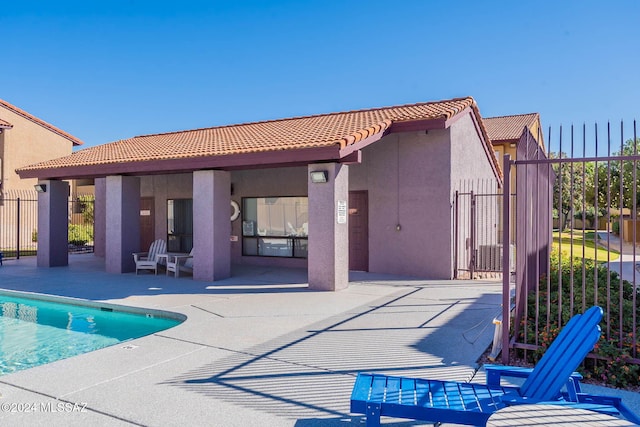 rear view of house featuring a community pool and a patio area