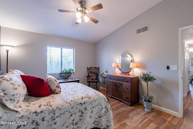 bedroom with light wood-type flooring, vaulted ceiling, and ceiling fan