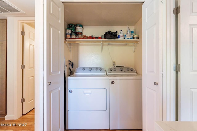 washroom featuring light hardwood / wood-style floors and washing machine and clothes dryer