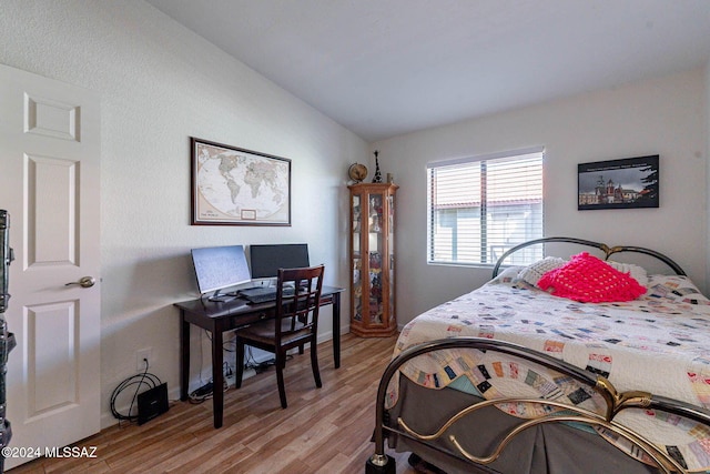 bedroom featuring lofted ceiling and light wood-type flooring