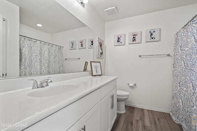 bathroom with hardwood / wood-style floors, vanity, and toilet