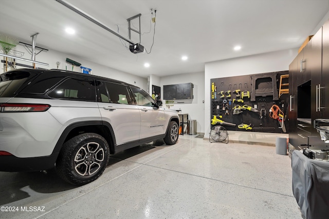 garage with a workshop area and a garage door opener