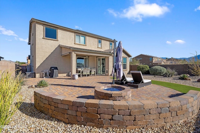 rear view of house with a patio and a fire pit