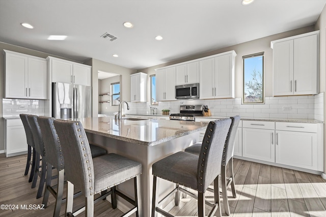 kitchen with white cabinetry, sink, light hardwood / wood-style flooring, and appliances with stainless steel finishes