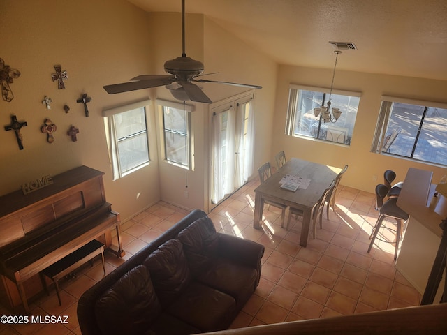 tiled living room featuring ceiling fan, a textured ceiling, and lofted ceiling