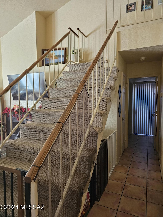 stairway with tile patterned floors