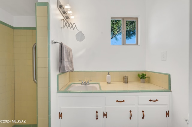 bathroom featuring a tile shower and vanity