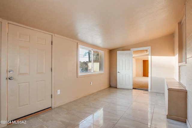 unfurnished room featuring lofted ceiling