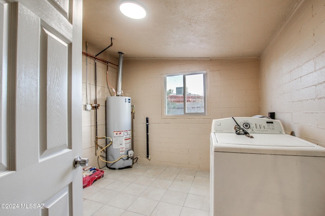 clothes washing area with washer / dryer, a textured ceiling, and gas water heater