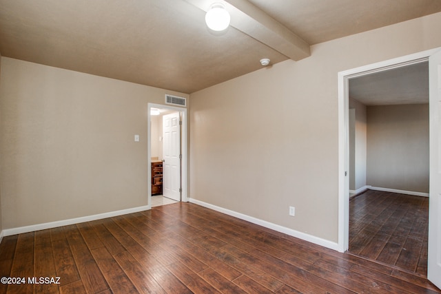 spare room with vaulted ceiling with beams and dark wood-type flooring