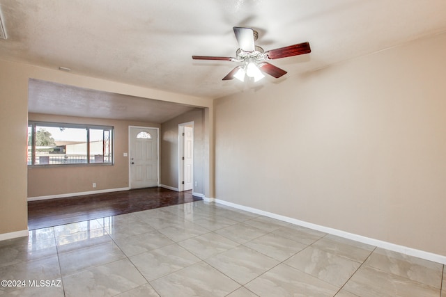 spare room with ceiling fan, light hardwood / wood-style floors, and a textured ceiling