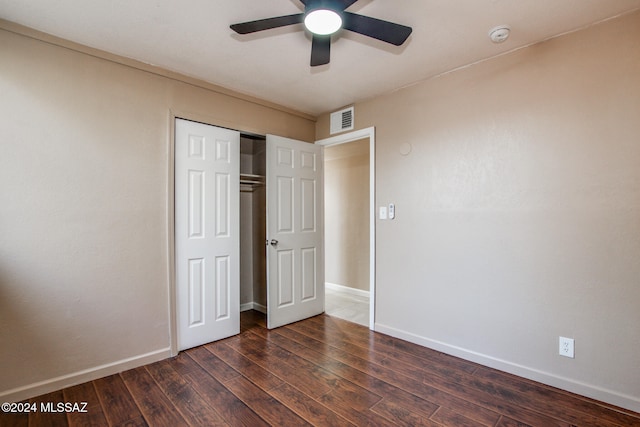 unfurnished bedroom with dark hardwood / wood-style floors, ceiling fan, and a closet