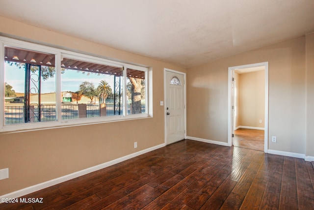 entryway with dark hardwood / wood-style flooring and lofted ceiling