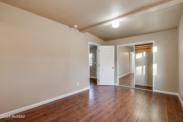 unfurnished bedroom featuring vaulted ceiling with beams, a closet, and dark wood-type flooring