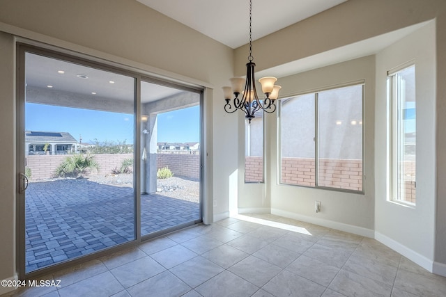 unfurnished dining area with light tile patterned flooring and an inviting chandelier