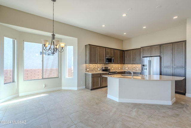 kitchen with decorative backsplash, stainless steel appliances, sink, decorative light fixtures, and an inviting chandelier