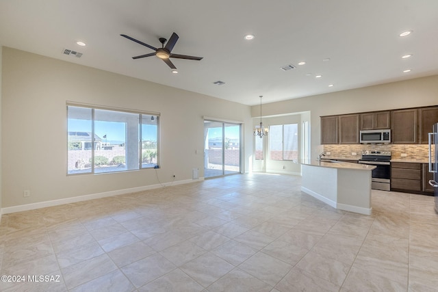 kitchen featuring decorative light fixtures, decorative backsplash, light tile patterned flooring, ceiling fan with notable chandelier, and appliances with stainless steel finishes