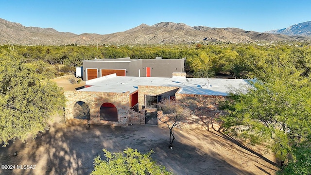 view of front of house with a chimney, a gate, a mountain view, and stucco siding