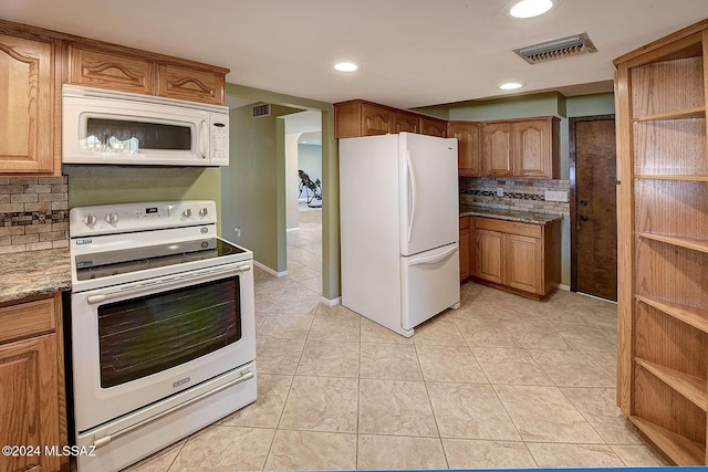 kitchen with light stone countertops, light tile patterned floors, white appliances, and decorative backsplash