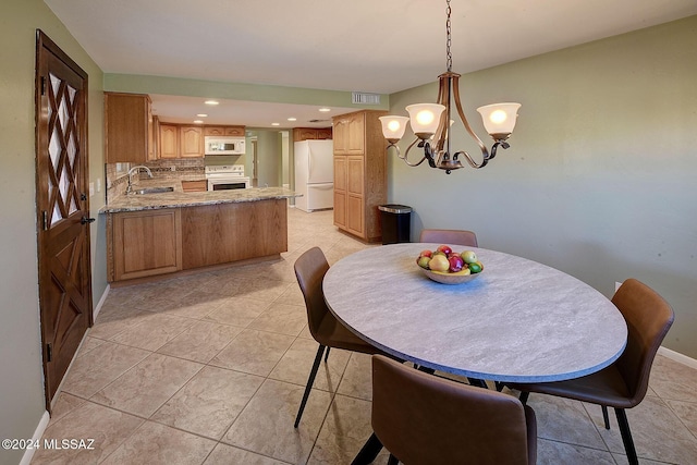 dining space featuring sink, light tile patterned floors, and a notable chandelier