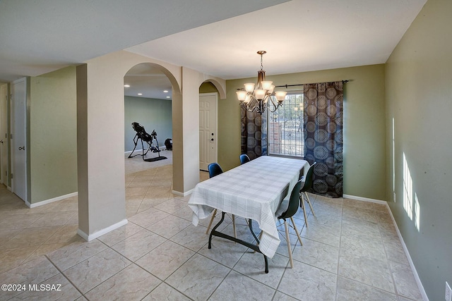 dining area with light tile patterned floors and a chandelier