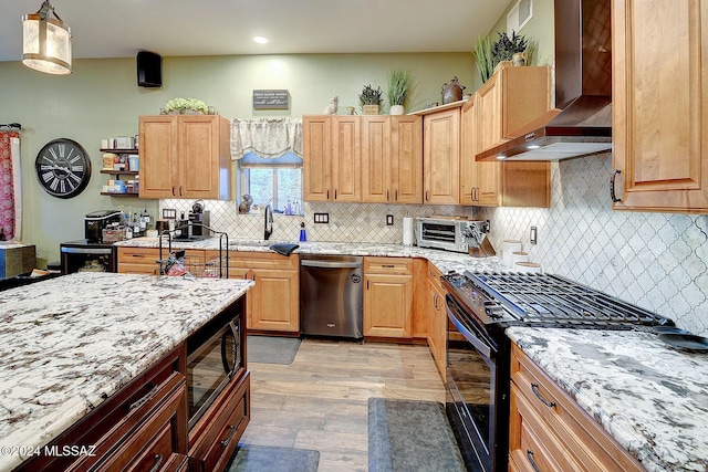 kitchen with pendant lighting, built in microwave, dishwasher, gas stove, and wall chimney exhaust hood