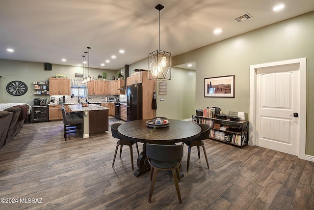 dining room with dark hardwood / wood-style floors and a notable chandelier