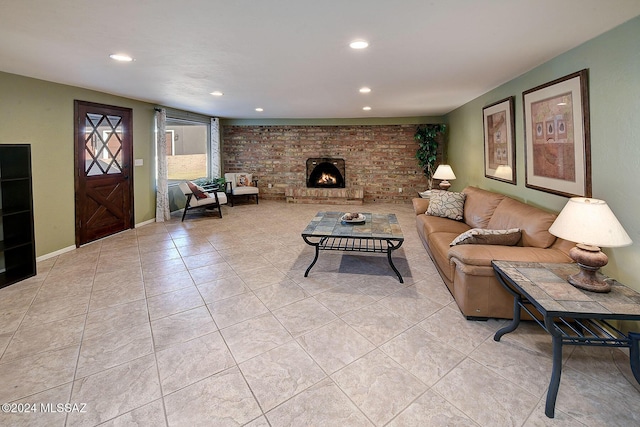 living room with a brick fireplace and light tile patterned floors