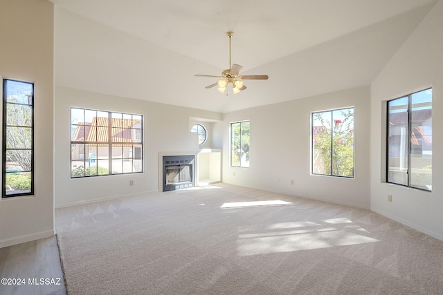 unfurnished living room with light colored carpet, high vaulted ceiling, and ceiling fan