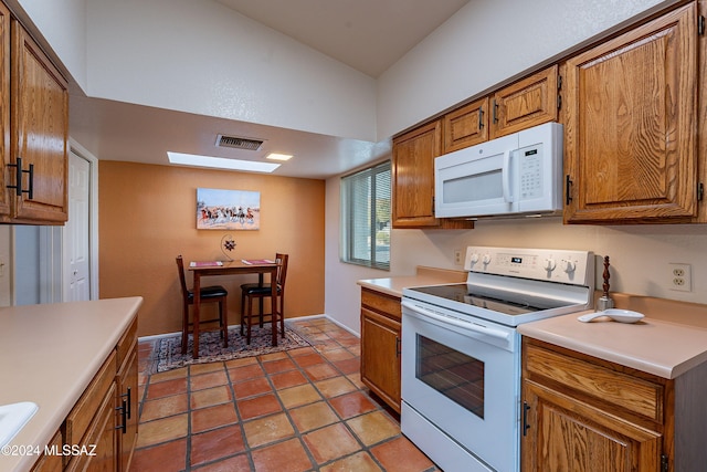 kitchen with sink, light tile patterned floors, and white appliances