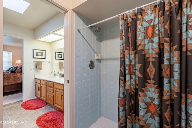 bathroom with tile patterned flooring, vanity, curtained shower, and a skylight