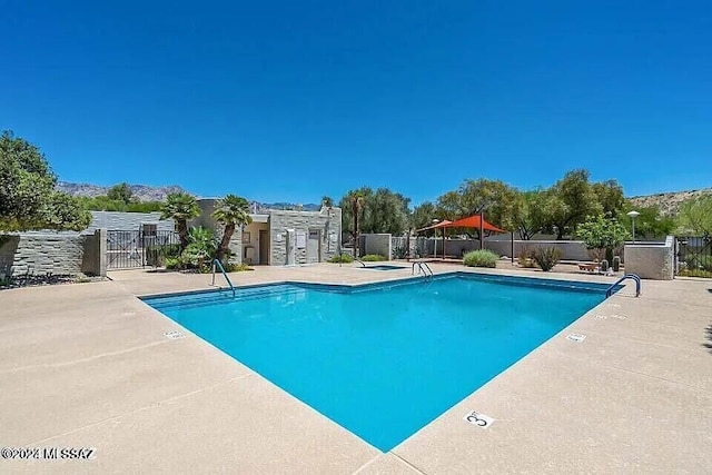 view of pool with a community hot tub and a patio area