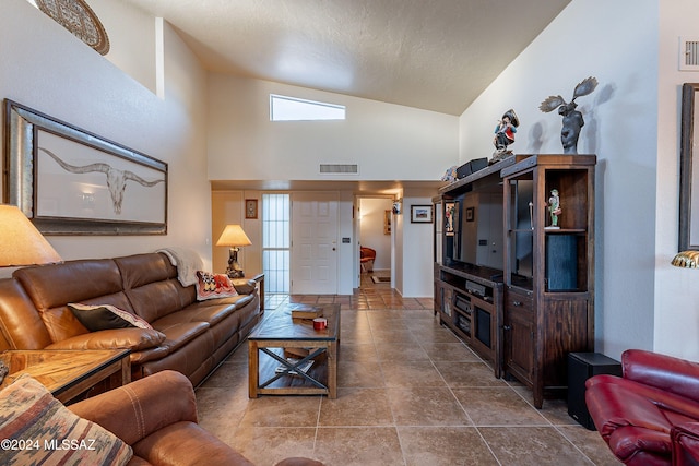 living room featuring high vaulted ceiling and a textured ceiling