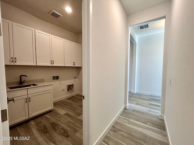 interior space featuring a sink, visible vents, and wood finished floors