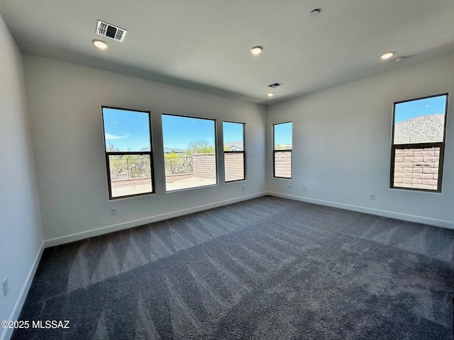 unfurnished room featuring dark carpet, baseboards, visible vents, and recessed lighting