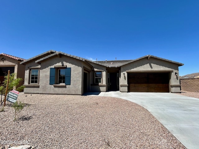 single story home with a garage, stucco siding, concrete driveway, and a tile roof