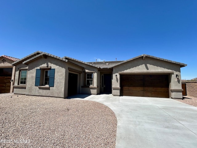 view of front of home with concrete driveway, a garage, and stucco siding