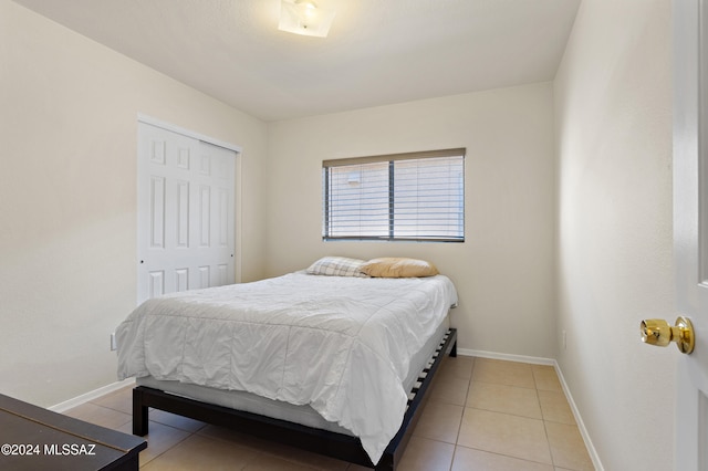 bedroom featuring tile patterned flooring and a closet